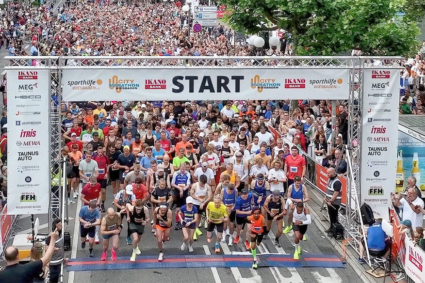 Zahlreiche Läuferinnen und Läufer beim Start eines Rennens.