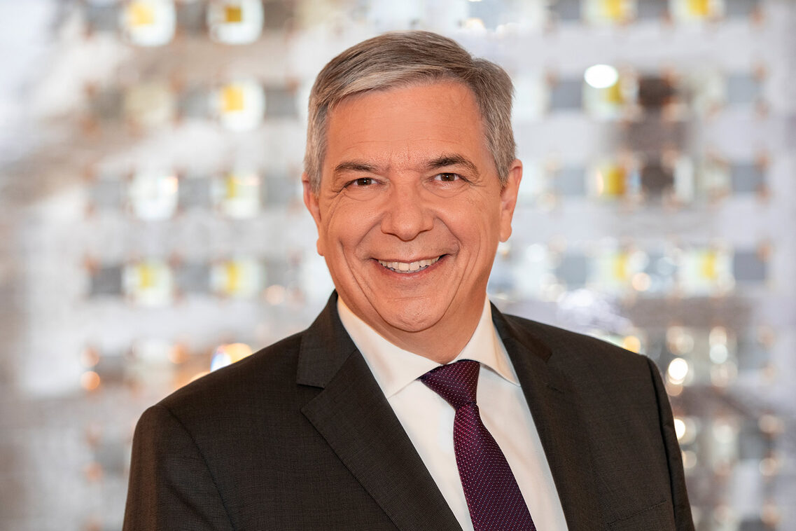 Mann mit grauen Haare in Anzug mit Schlips.