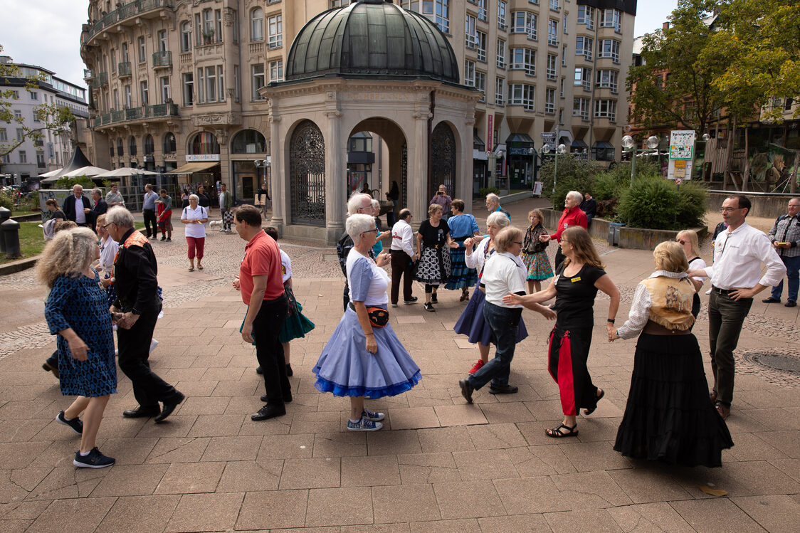 Personen tanzen Square Dance auf dem Kranzplatz.