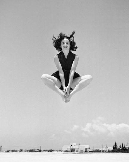 Frau springt am Strand in die Luft