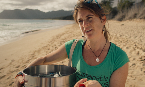 Frau mit Mülltonne am Strand