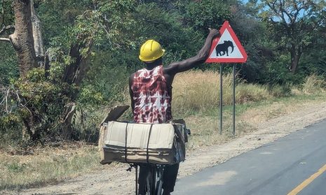 MAnn auf Fahrrad mit Schild Elefant