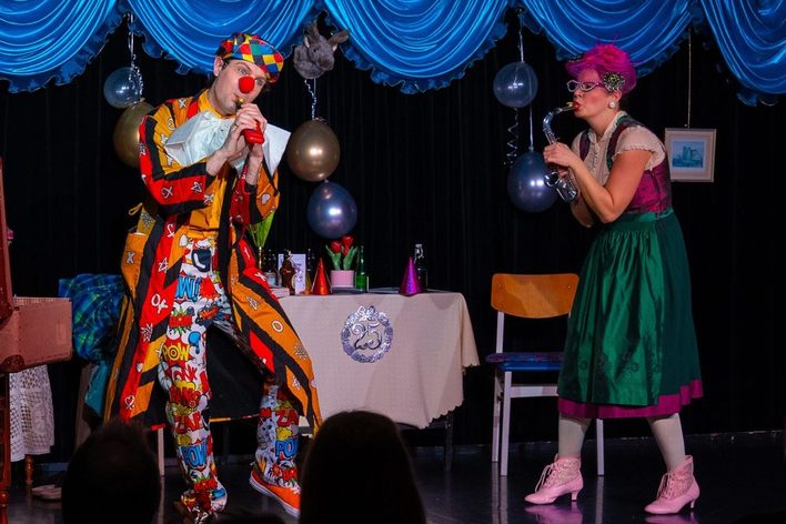 Clown und Frau mit Saxophon auf der Bühne