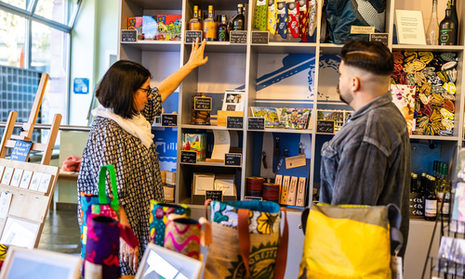 Dunkelhaariuge Frau zeigt Besucher die Wiesbadener Produkte