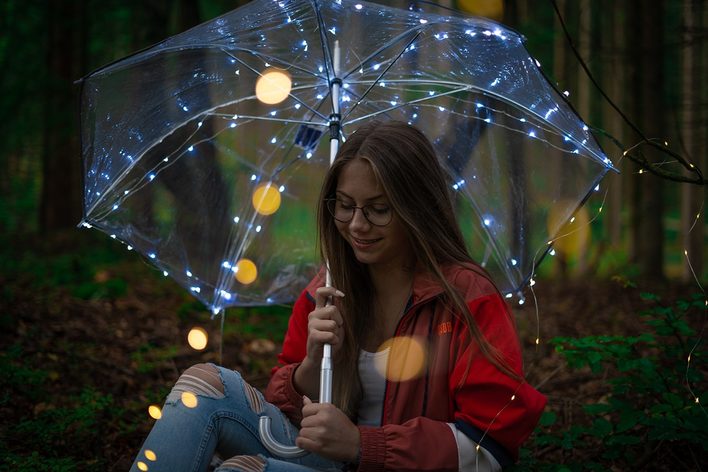 Mädchen mit beleuchtetem Regenschirm