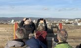 Menschen fotografieren über einen Zaun hinweg eine Fernsicht