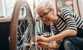 Junge Frau bei Fahrrad reparieren