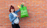 Junge Frau mit Stoffbeutel in der Hand auf dem Zero Waste steht