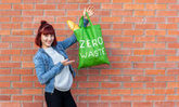 Frau präsentiert Tüte mit Schriftzug "Zero Waste"